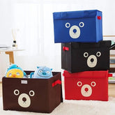Stack of colorful storage boxes with bear faces on a light background